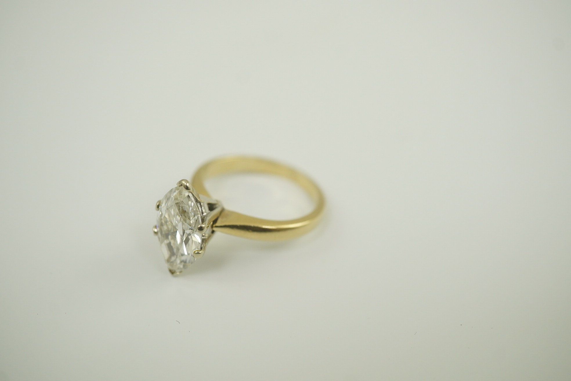 A modern 14k gold and solitaire marquise diamond set ring